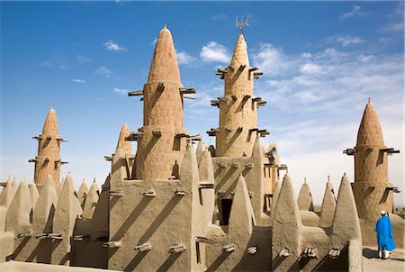 Mali, Delta intérieur du Niger. Éclipsée par les minarets, l'imam de la mosquée de Kotaka appelle les fidèles à la prière depuis le toit de la mosquée. Photographie de stock - Rights-Managed, Code: 862-03437234