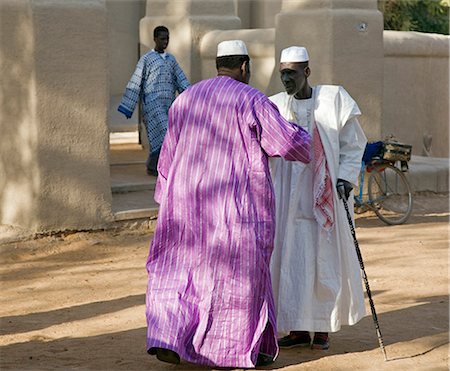 Mali, Mopti. Zwei Männer im Chat außerhalb der Moschee von Mopti nach am Nachmittag gebeten. Diese feinen Sudan-Stil-Moschee wurde 1935 erbaut und vor kurzem in seinen früheren Zustand repariert. Stockbilder - Lizenzpflichtiges, Bildnummer: 862-03437230