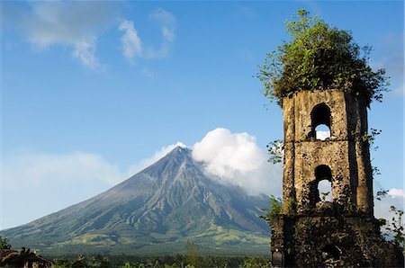 Philippines,Luzon Island,Bicol Province. Cagsawa Church Belfrey Ruins and Mount Mayon (2462m). Near Perfect Volcano Cone with plume of smoke. This location is where 1200 people were buried alive in the 1814 eruption. Foto de stock - Con derechos protegidos, Código: 862-03437314