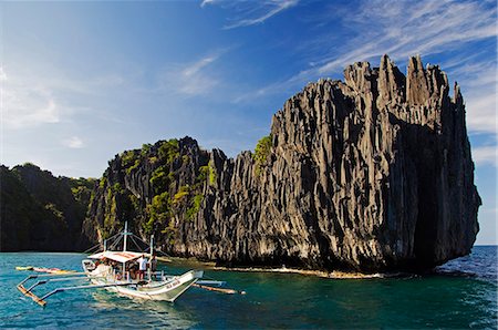 philippine islands view - Philippines,Palawan Province,El Nido,Bacuit Bay. Miniloc Island - catamaran for island hopping in Small Lagoon with unusual jagged limestone rock formations. Stock Photo - Rights-Managed, Code: 862-03437317