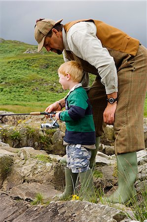Gordon Muir,stalker and ghillie at Glen Batrick Lodge,teaches a young guest to fish Stock Photo - Rights-Managed, Code: 862-03437354