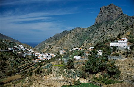 The whitewashed houses of Vallehermoso village sit amongst the palm groves and tightly terraced hillsides of La Gomera Stock Photo - Rights-Managed, Code: 862-03437362