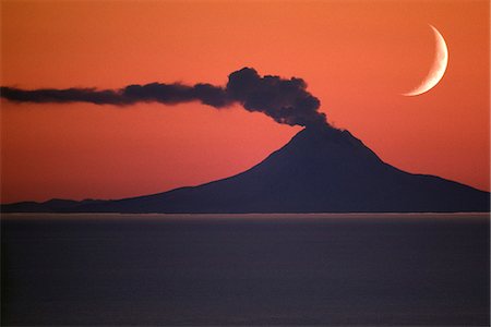 simsearch:862-03437538,k - USA, Alaska. Un croissant de lune s'élève au-dessus de Mont Augustine durant une phase éruptive en 1986. Mont Augustine est le long de la péninsule de l'Alaska dans Cook Inlet environ 70 km SW d'Homère. Photographie de stock - Rights-Managed, Code: 862-03437538