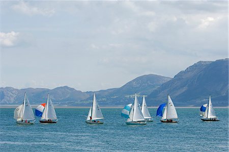 dinghy - Wales,Anglesey,Beaumaris. Dinghies race during a regatta on the Menai Straits against the backdrop of the Snowdonia Mountains. Stock Photo - Rights-Managed, Code: 862-03437764