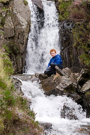 Wales,Conwy,Snowdonia. A young boy sits beside a waterfall in Cwm Idwal at the foot of the Glyders Foto de stock - Con derechos protegidos, Código: 862-03437833