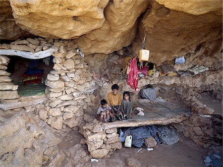 A spacious rock shelter dwelling of a pastoral Bedu family in the Haghir Mountains. Caves and overhanging rock are used extensively by pastoralists who make up the majority population of the island’s interior. Families will often own a conventional stone house in the lowlands too. Foto de stock - Con derechos protegidos, Código: 862-03437917