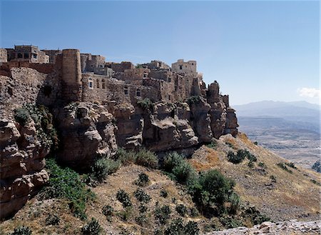 simsearch:862-03360380,k - Perched on the edge of the Tabal Kawkaban (9,350 feet) is the ancient stone town of Kawkaban,which served as a mountain fortress for the residents of Shibam,living at the foot of the mountain,over 1,000 feet below.Inaccessible from most sides,the stout door of the town's only gate is still closed and locked each night. Foto de stock - Direito Controlado, Número: 862-03437941