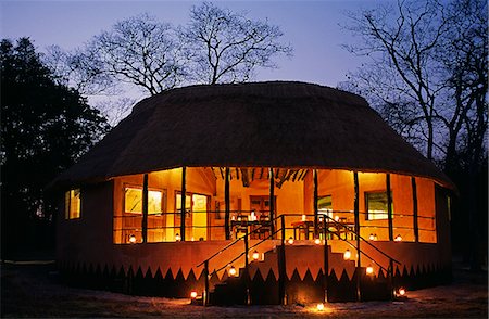 simsearch:862-03361158,k - Zambia; Kasanka national park,Wasa lodge. New Bar,dining & lounge hut at Wasa Lodge,lit up in the evening. Fotografie stock - Rights-Managed, Codice: 862-03438022