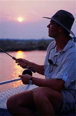 pesca con la mosca - Zambia,Lower Zambezi National Park. Fly-fishing for tiger fish on the Zambezi River. Fotografie stock - Rights-Managed, Codice: 862-03438042