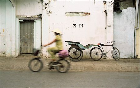 simsearch:862-08700131,k - Woman riding bicycle along street, Ben Tre, Vietnam Foto de stock - Direito Controlado, Número: 862-03714202