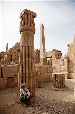 Ägypten, Karnak. Ein Tourist sitzt am Fuße eines alten geschnitzte Säule am Karnak. Stockbilder - Lizenzpflichtiges, Bildnummer: 862-03710908