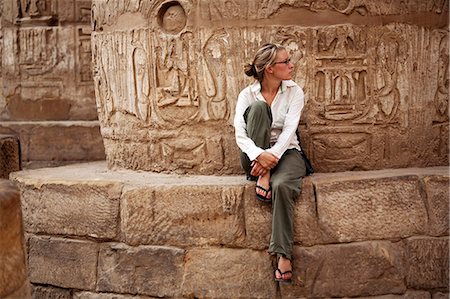 Ägypten, Karnak. Ein Tourist sitzt an der Basis einer massiven steinernen Spalte in die große Hypostyle-Halle. Stockbilder - Lizenzpflichtiges, Bildnummer: 862-03710911