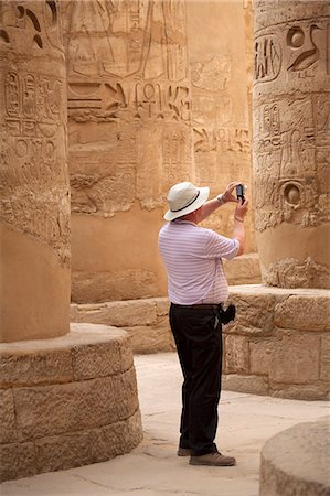 simsearch:862-03713647,k - Egypt, Karnak. A tourist photographs the massive stone columns in the Great Hypostyle Hall. Stock Photo - Rights-Managed, Code: 862-03710913