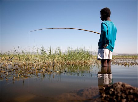 simsearch:862-03437076,k - Ethiopie, lac Awassa. Un jeune garçon des poissons avec une canne à pêche en bambou. Photographie de stock - Rights-Managed, Code: 862-03711176