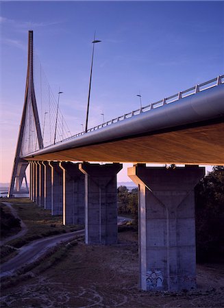 France, Normandie, Pont de Normandie. Coucher de soleil sur le Pont de Normandie. Le pont ouest au-dessus de la rivière Seine, il relie Le Havre & Honfleur. Achevé en 1995, il était à l'époque, le plus long pont à haubans de route. Conçu par Michel Virlogeux. Photographie de stock - Rights-Managed, Code: 862-03711230