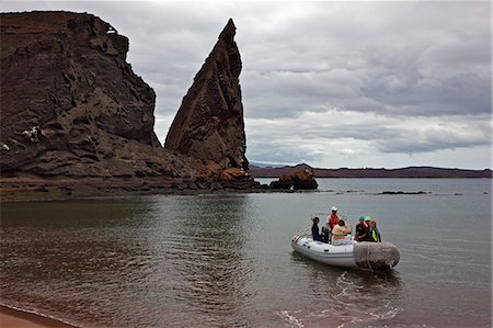 Îles Galápagos, un panga ""ou en caoutchouc gonflable miteux amène les visiteurs à l'île de Bartolome. Photographie de stock - Rights-Managed, Code: 862-03711555