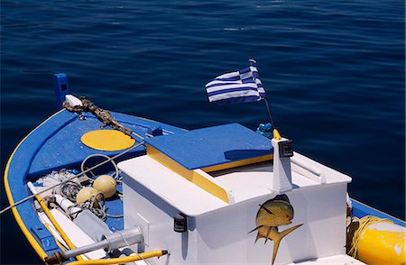 paraurti - Greek fishing boat and flag afloat on aquamarine water,Greece Fotografie stock - Rights-Managed, Codice: 862-03711689