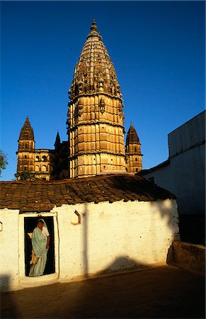 simsearch:862-06825860,k - A local woman emerges from her home behind which soars the striking outline of the Chaturbuj Mandir,or temple. Foto de stock - Con derechos protegidos, Código: 862-03711911