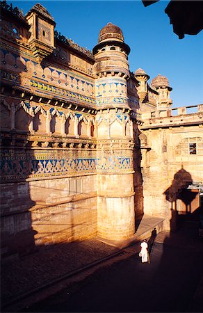 Built atop a narrow rocky hill almost 100m above the plains,the massive fort of Gwalior is among India's most impressive. Viewed here is the Hathia Paur Gate and the southern facade of the 16th-century Man Mandir,the fort's most spectacular palace. Foto de stock - Direito Controlado, Número: 862-03711912