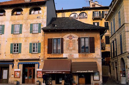 Pastel coloured shops and houses lining Piazza Motta the main square in Orta San Giulio at sunset. Stock Photo - Rights-Managed, Code: 862-03712166