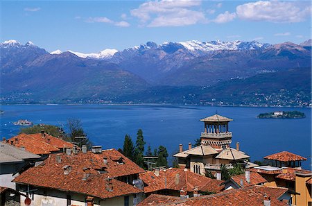 View of Lake Maggiore showing typical red roofs and snow capped mountains. Fotografie stock - Rights-Managed, Codice: 862-03712163