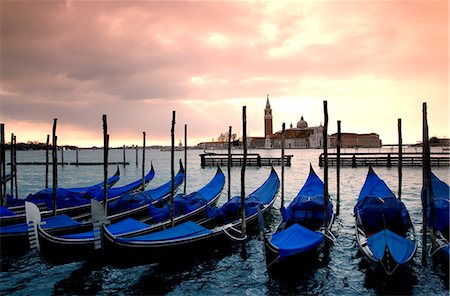 Italy, Veneto, Venice; Gondolas tied up at the Bacino di San Marco lagoon with San Giorgio Maggiore in the background Foto de stock - Con derechos protegidos, Código: 862-03712397