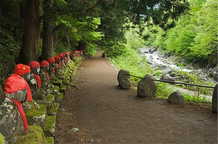 Kanmangafuchi zone de la ville de Nikko. Les statues de pierre de Narabijizo porter des dossards rouges alignés à côté de la rivière Photographie de stock - Rights-Managed, Code: 862-03712498