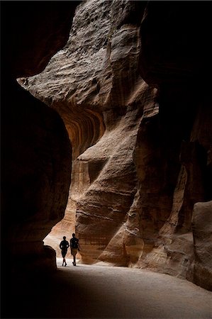 simsearch:841-02713799,k - Jordan, Petra. A couple wanders down the depths of the Siq at Petra. Fotografie stock - Rights-Managed, Codice: 862-03712596