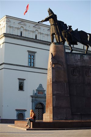 Lithuania, Vilnius, Woman Sitting In Front Of Statue Of Gediminas With Poyal Palace In Backgroun. Stock Photo - Rights-Managed, Code: 862-03712844