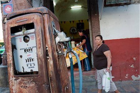 simsearch:862-03712902,k - San Miguel de Allende, Mexique. Une femme marchant dans la rue à la recherche à une pompe à essence rouillé Photographie de stock - Rights-Managed, Code: 862-03712895