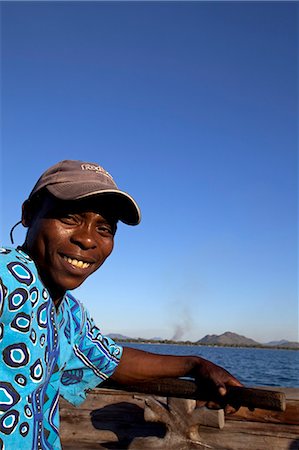 Malawi, Lake Malawi, Nkwichi Lodge. A boatman crosses the Mozambican side of Lake Malawi to reach the lodge. Foto de stock - Con derechos protegidos, Código: 862-03713069