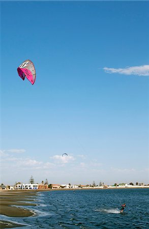 Afrique, Namibie, Walvis Bay. Kite Surfeurs attraper le vent sur la terre ferme dans la baie Photographie de stock - Rights-Managed, Code: 862-03713105