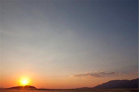 Africa, Namibia, Damaraland, Brandberg Mountain. The sun sets over the foothills Foto de stock - Con derechos protegidos, Código: 862-03713114