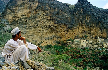 Oman, Dakhiliyah, Jebel Hajar, Wajmah. A man contemplates the view near the terraces of Wajmah village high in the Jebel Hajar. Foto de stock - Direito Controlado, Número: 862-03713129