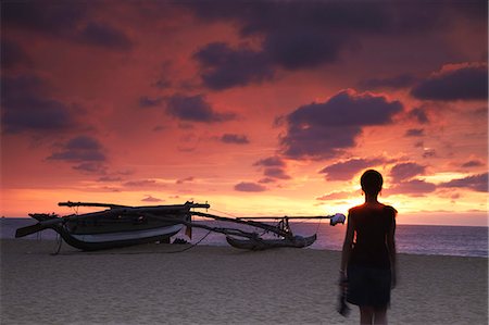 simsearch:862-06543034,k - Femme qui marche sur la plage au coucher du soleil, Negombo, Sri Lanka. Photographie de stock - Rights-Managed, Code: 862-03713583