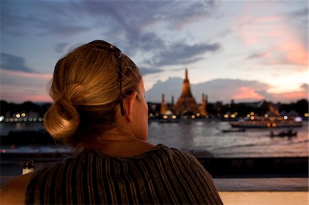 simsearch:862-05999536,k - Bangkok, Thailand. A western woman watching sunset over Wat Arun in Bangkok Stock Photo - Rights-Managed, Code: 862-03713778
