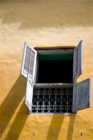 simsearch:862-03737256,k - Tanzanie, Zanzibar, Stone Town. Une fenêtre avec volets dans un mur peints de couleurs vives d'un vieux bâtiment à Stone Town. Photographie de stock - Rights-Managed, Code: 862-03713935