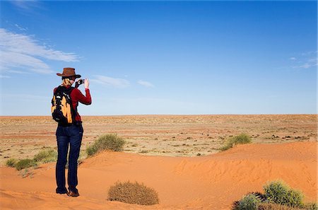 Australien, Queensland, Simpson Desert National Park, Birdsville. Eine Frau sieht über die Simpson Wüste aus einer Sanddüne. Stockbilder - Lizenzpflichtiges, Bildnummer: 862-03736209