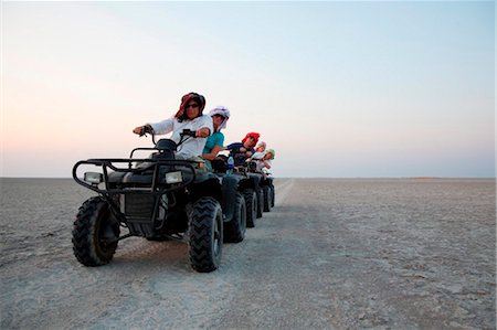 salt plains of africa - Botswana, Makgadikgadi, Jack's Camp. Tourists driving quad bikes across the Makgadikgadi pans at sunset. Stock Photo - Rights-Managed, Code: 862-03736357