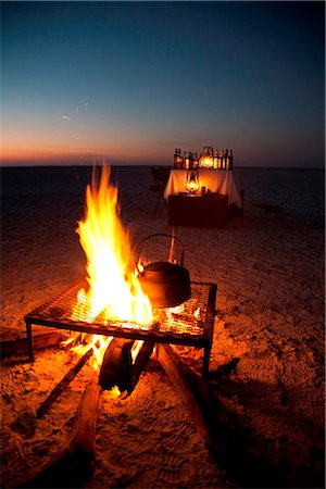 désert de kalahari - Botswana, Makgadikgadi. Une bouilloire revient sur le braai devant un bar bien approvisionné. Photographie de stock - Rights-Managed, Code: 862-03736361