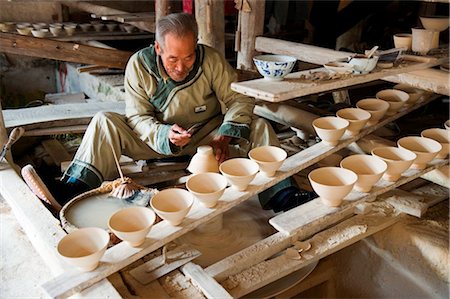 factory and ceramics - China, Jiangxi Province, Jingdezhen city the home of china, Qing and Ming Ancient Pottery Factory, a potter making dishes Stock Photo - Rights-Managed, Code: 862-03736568