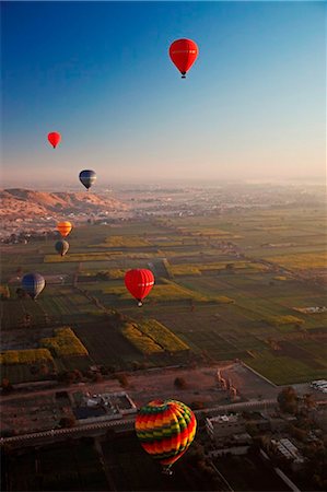 Egypt, Qina, Al Asasif, Eight hot air balloons over the Valley of the Kings and Queens with Luxor and the River Nile Stock Photo - Rights-Managed, Code: 862-03736637