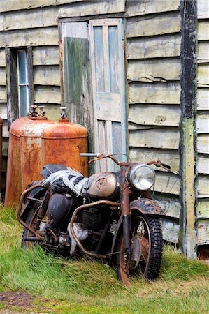 Falkland Islands; Carcass Island. A 1960s BSA motorbike propped against a the wooden outbuilding of a sheep farm. Fotografie stock - Rights-Managed, Codice: 862-03736678