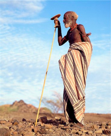 sage - Kenya, le District de Turkana. Un vieil homme de Turkana, tenant son tabouret en bois sculpté cum appui-tête dans sa main droite. Photographie de stock - Rights-Managed, Code: 862-03736761