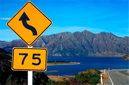 simsearch:841-03674272,k - New Zealand, Cantebury & West Coast, Lake Hawea. The road and speed limit sign down to Lake Hawea on highway 6 to Wanaka Foto de stock - Direito Controlado, Número: 862-03737033