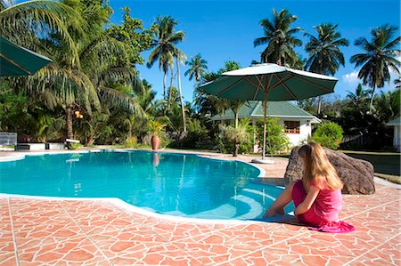 simsearch:862-03808521,k - Seychelles, Mahe. A girl dabbling her toes in the pool at L Habitation Cerf, a hotel on an island off the north coast Foto de stock - Con derechos protegidos, Código: 862-03737088