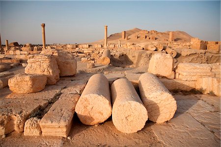 syrier - Syria, Palmyra. Fallen columns and arches litter the ground across the site of Queen Zenobia's ancient city at Palmyra. Foto de stock - Con derechos protegidos, Código: 862-03737195