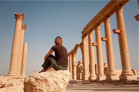 Syria, Palmyra. A tourist sits amongst the ancient ruins of Queen Zenobia's city at Palmyra. Stock Photo - Rights-Managed, Code: 862-03737201