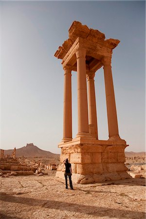 simsearch:862-03737191,k - Syria, Palmyra. A tourist  stands amongst the ancient ruins of Queen Zenobia's city at Palmyra. Foto de stock - Con derechos protegidos, Código: 862-03737202