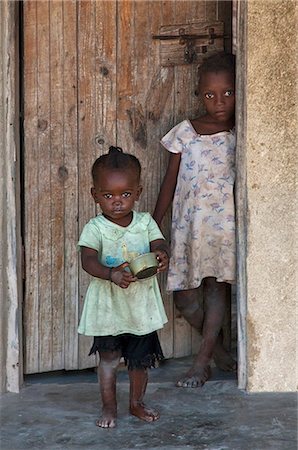 simsearch:862-03737306,k - Tanzania, Zanzibar. Two young girls at the door of their house in Jambiani village. Fotografie stock - Rights-Managed, Codice: 862-03737288